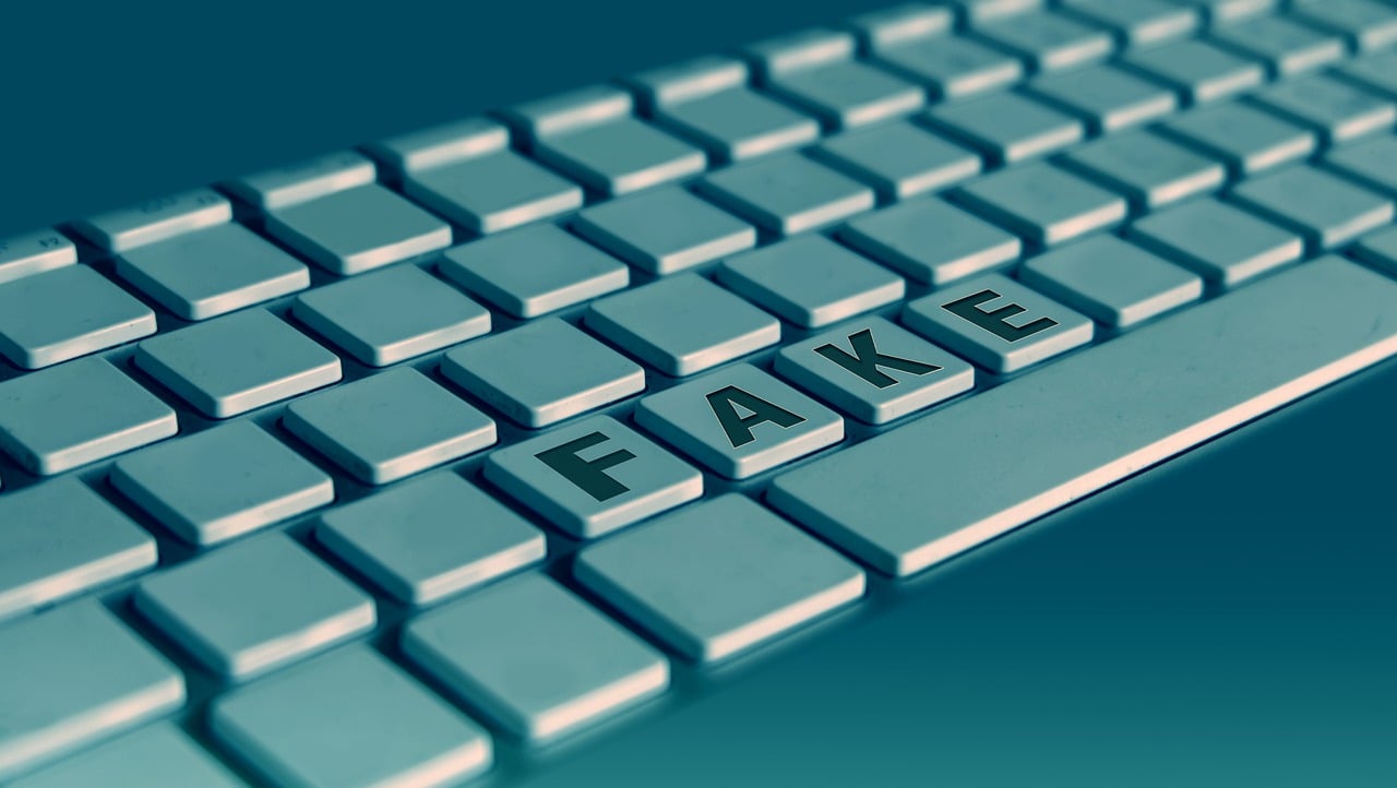 outline of computer keyboard without lettering on individual keys, "fake" spelled out on bottom row